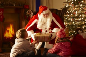 Father Christmas giving gift to children in grotto