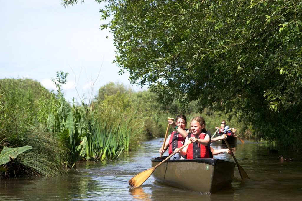 Family paddling on canoe safari at Slimbridge