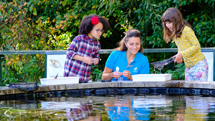 Children pond dipping with WWT staff member