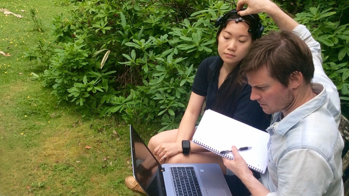 WWT staff member adjusting a headset on a volunteer, which is being used to measure wellbeing-related statistics