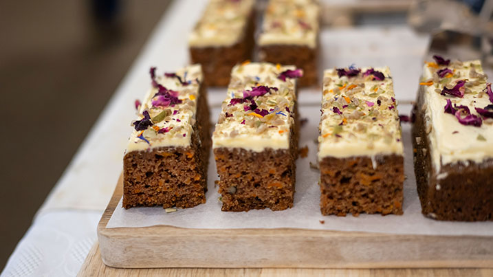 A plate of cake slices with icing and edible flower decorations