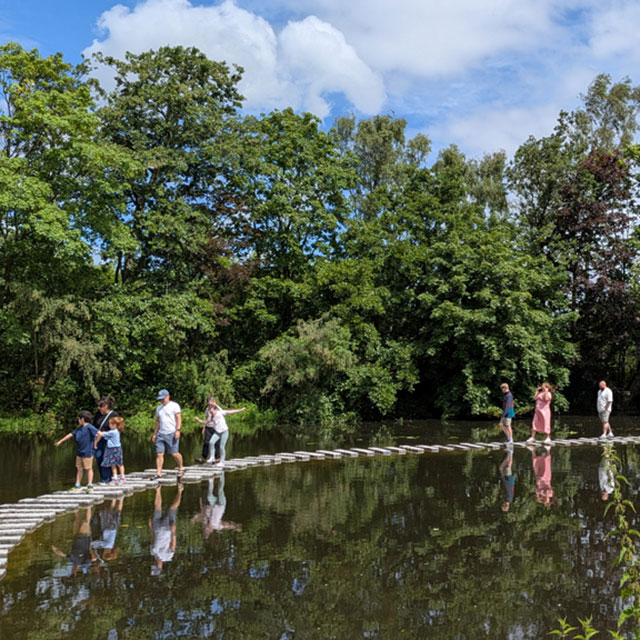 Families walking across Europe's longest continuous stretch of stepping stones at Martin Mere, Lancashire